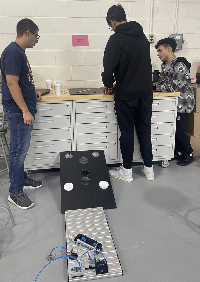 LeveI I students working on their Final Pneumatic Project where they get to use what they learned and add creativity to design and build a circuit of their own choice using pneumatics. This team decided to make a Pneumatically Operated Skee Ball Game.