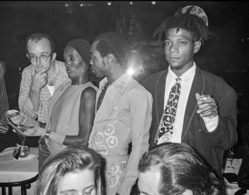 60sto70sto80s's tweet photo. Midtown Manhattan, NYC (1986). Keith Haring, Grace Jones, Fela Kuti, and Jean-Michel Basquiat enjoy their time at Mr. Chow restaurant on 57th Street. Photographed by Andy Warhol. https://t.co/CbMuBEa7a8