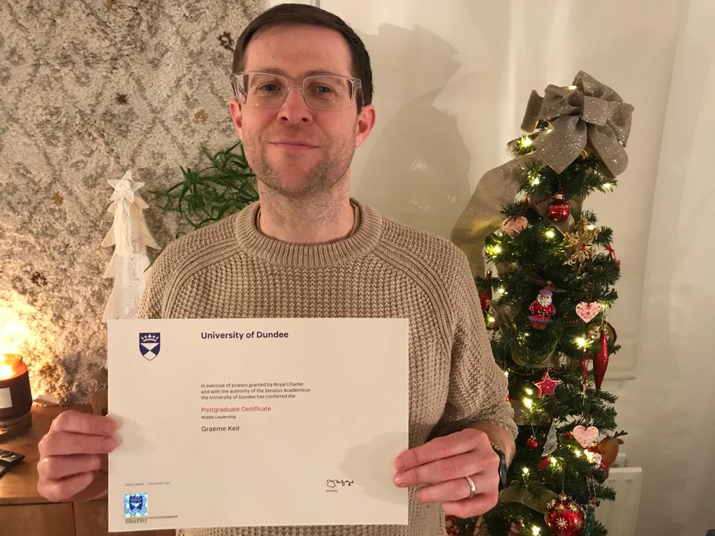 keir_mr's tweet photo. New glasses + new post-grad certificate + xmas tree = smug face 😉 https://t.co/XzG9QmxJJI