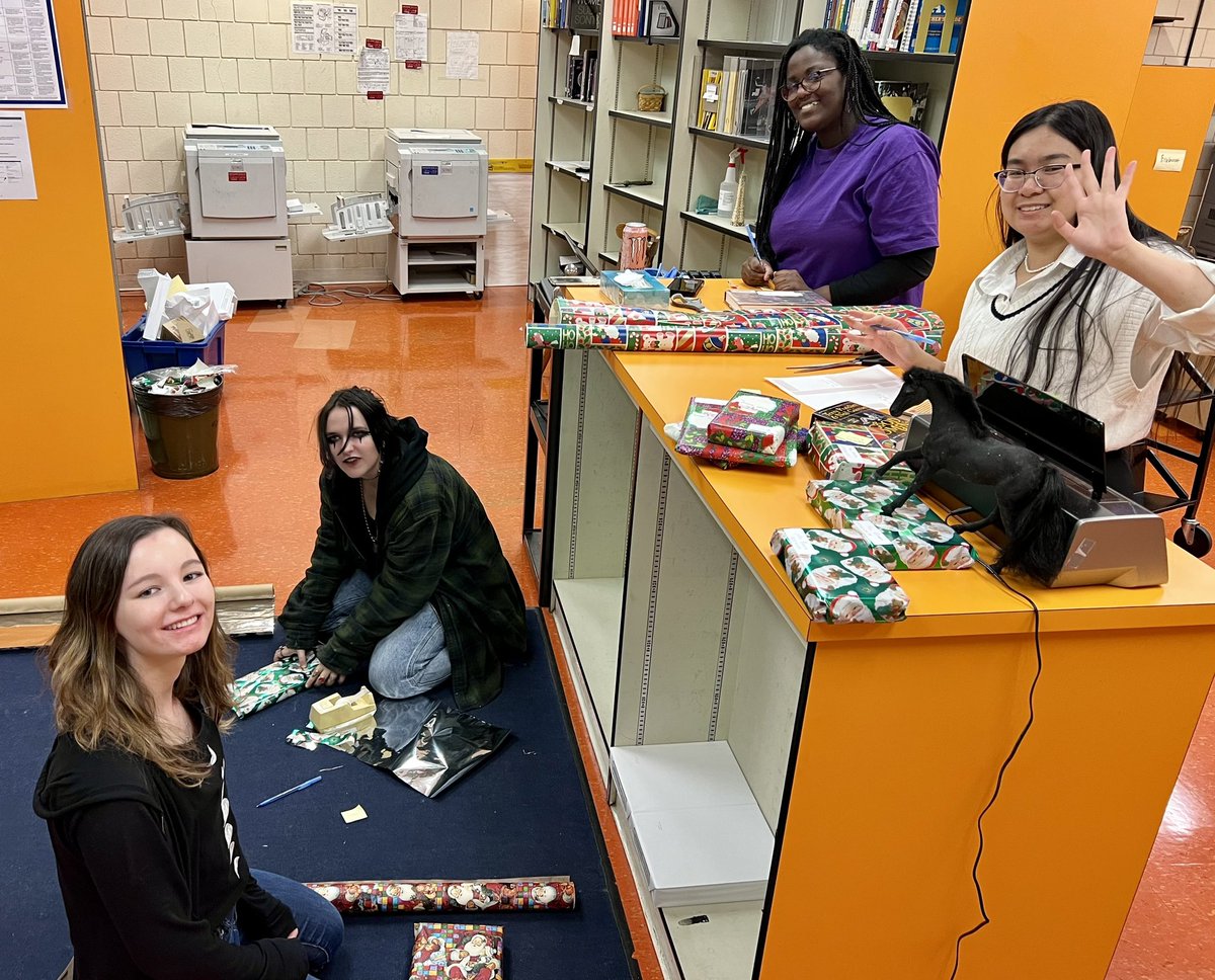CMWLibrary's tweet photo. Library helpers wrapping our teachers favorite books. Then under the tree they go so students can check them out, unwrap and have their teachers favorite book over Winter Break! #librarygames @CMiltonOfficial https://t.co/pQ1ykEARX0