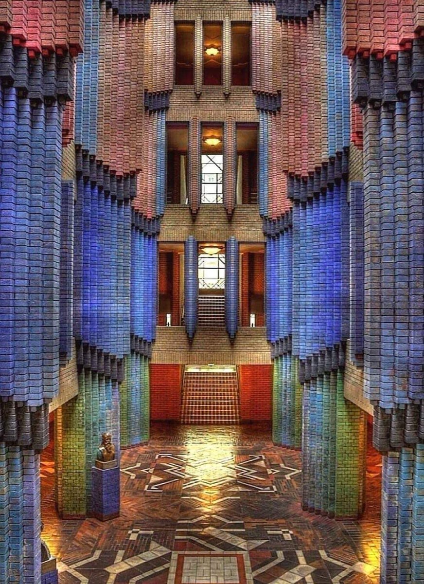 PETER BEHRENS,Dome Hall of Farbwerke Hoechst, Frankfurt,Germany.1921-24. Coloured bricks are illuminated by light that pours through domes at the top of the building, and the space is perfectly symmetrical.