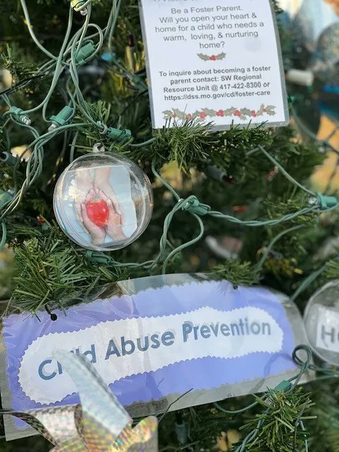 DSS_Missouri's tweet photo. Children’s Division team members decorated a Christmas tree for the 3rd Annual Holiday Tree Trail held at Mercy Park in Joplin. It advertised the need for foster parents in MO and featured pictures of the children searching for a forever home. #FosterMOKids https://t.co/GX5XRQYmsB