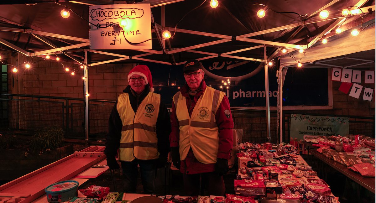 CarnforthRotary's tweet image. Carnforth Rotarians ran the Chocobola stall at the Christmas lights switch on in Market Square. The stall was very colourful  with lots of donated chocolate goodies. It was a very busy evening with everyone being a winner. The prize of course was chocolate in some shape or form.