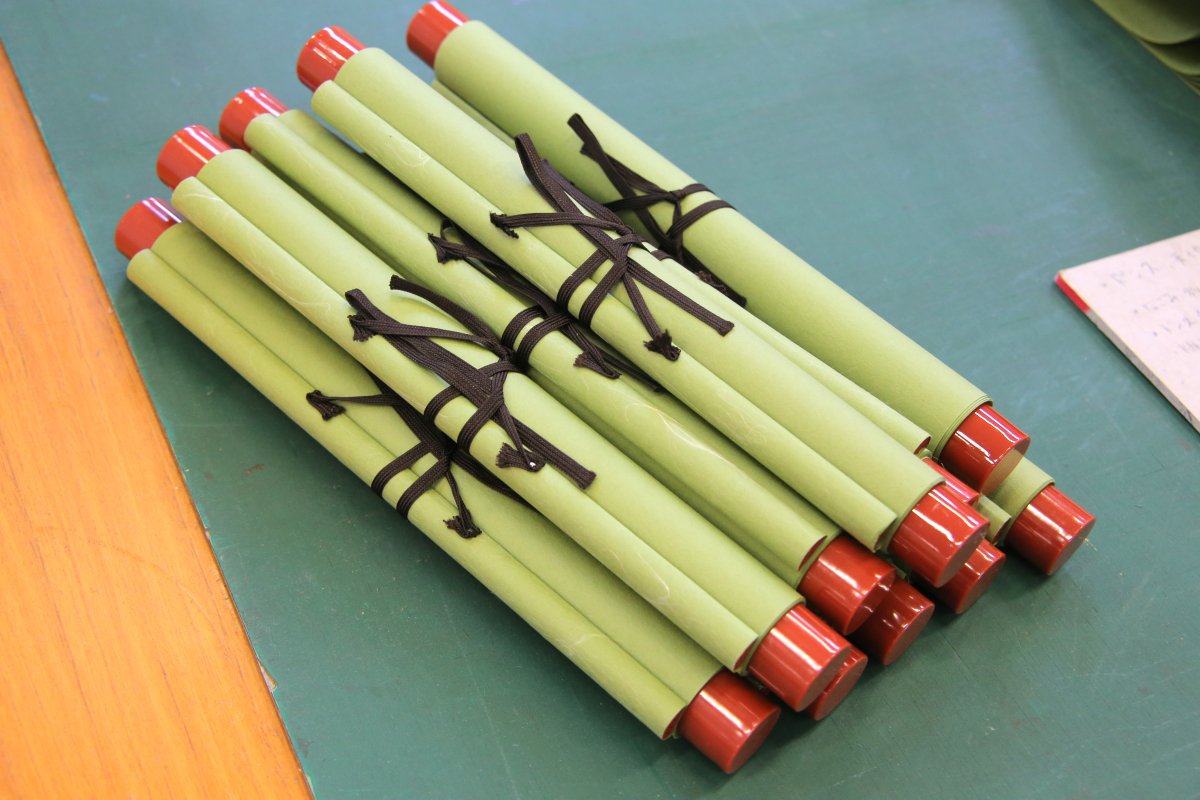 🧑‍🏭ni-wa工場見学ツアー👩‍🏭
今回は仮巻の様子をお届け。仮巻は作品の保存や展示に使う軸です。写真は軸棒となる紙管（しかん）を糊で貼り付けて巻いているところ。紙管が紙と平行になるようにバランスを意識しながら手早く巻いていきます。
 #和紙 #工場見学