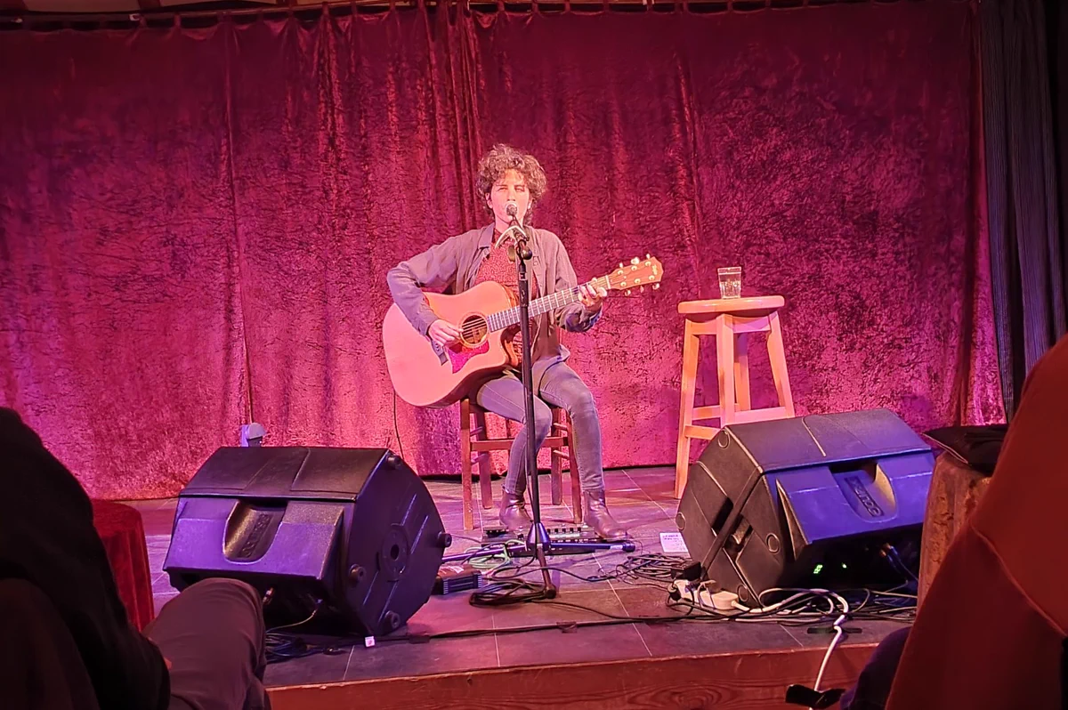 Tamar Eisenman singing and playing guitar on stage