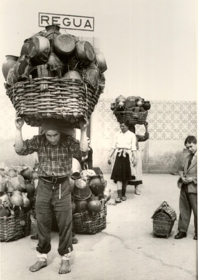 RuralPortugal's tweet photo. Oleiros de Bisalhães na Estação de Caminho-de-Ferro da Régua, transportando à cabeça cestos carregados com a loiça que produziram para vender na feira semanal de Vila Real (1955).

[📸 Joaquim Santos Júnior]

#PortugalRural https://t.co/DzPQ9KZ1jj