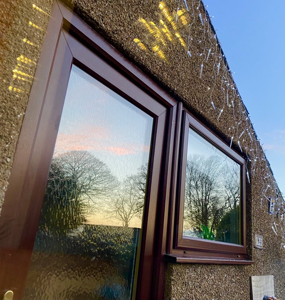 Jacmor63's tweet photo. Morning reflections in the kitchen door &amp; window. 
Why yes, I live in a house with a teensy lean-to kitchen. It used to be a larder &amp; coal bunker. The head bumps are worth it for the views. 

#sunrise #window #trees #scotland #writerslife #whereiwrite https://t.co/GllFY0kYn8