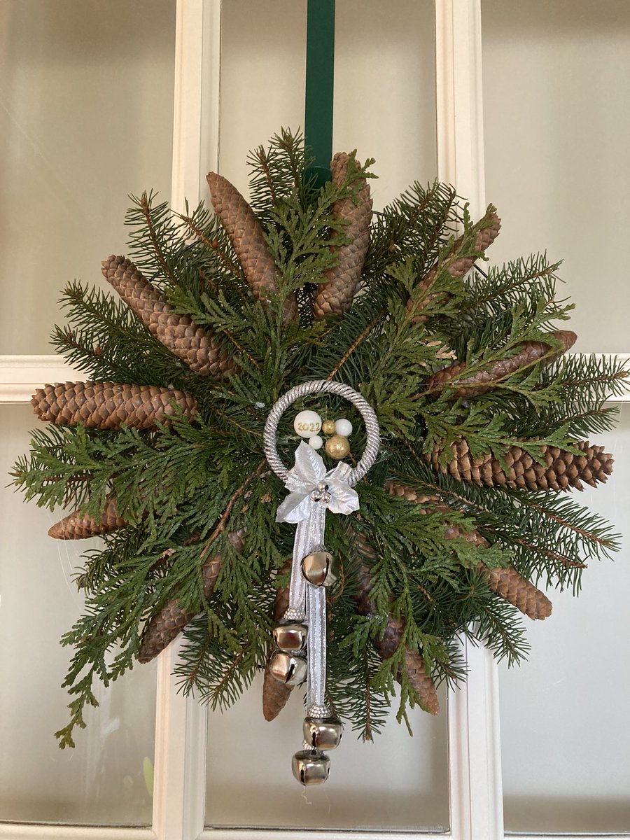 swelow's tweet photo. #Wreath with pine cone & greenery from our garden. Wheel wire form and bells decoration from @DollarTree and lots of hot glue! #WinterCraft #FlowerReport The pine cone were all closed and solid like a cigar when I picked them up but after day or 2 inside, they opened beautifully! https://t.co/A4yZ2FrcqN