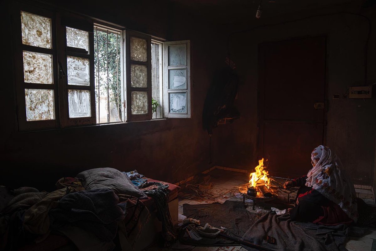 A Palestinian woman warms herself by a fire during a cold weather in Dier al-Balah, central Gaza Strip. (AP Photo/Fatima Shbair)