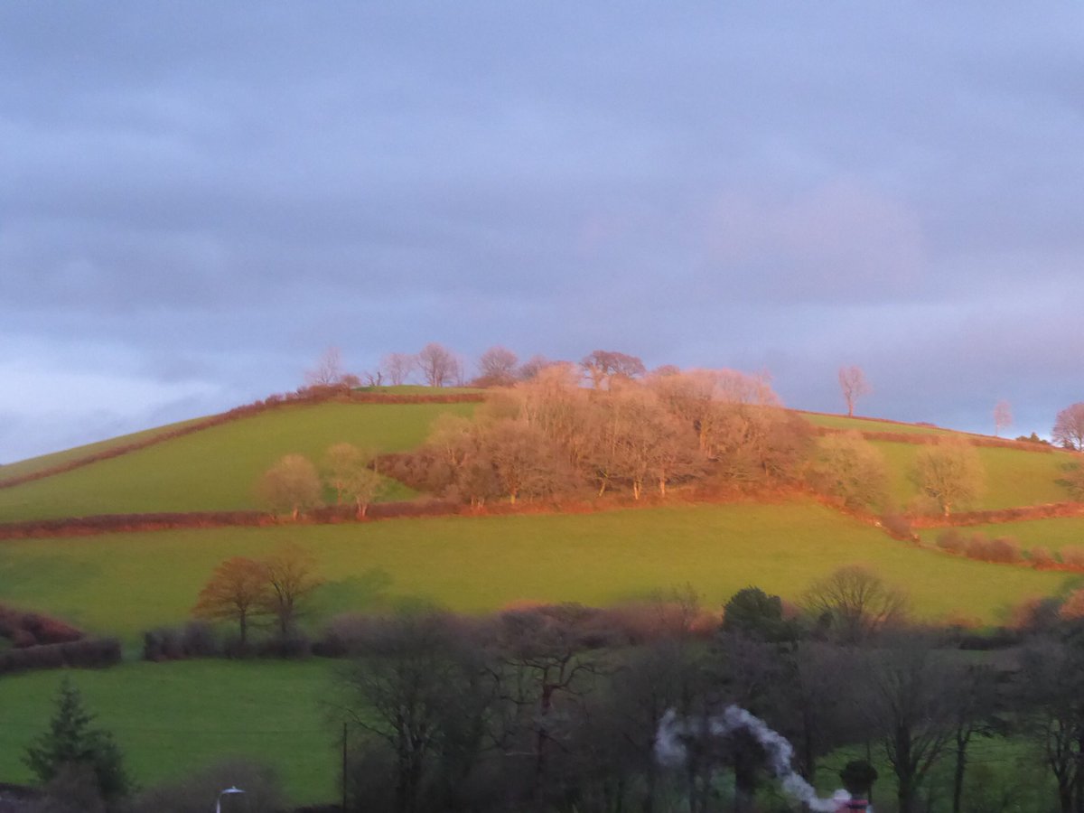 A rainbow seen through a Christmas star, clouds and golden light for #SmallBeautiesHour
