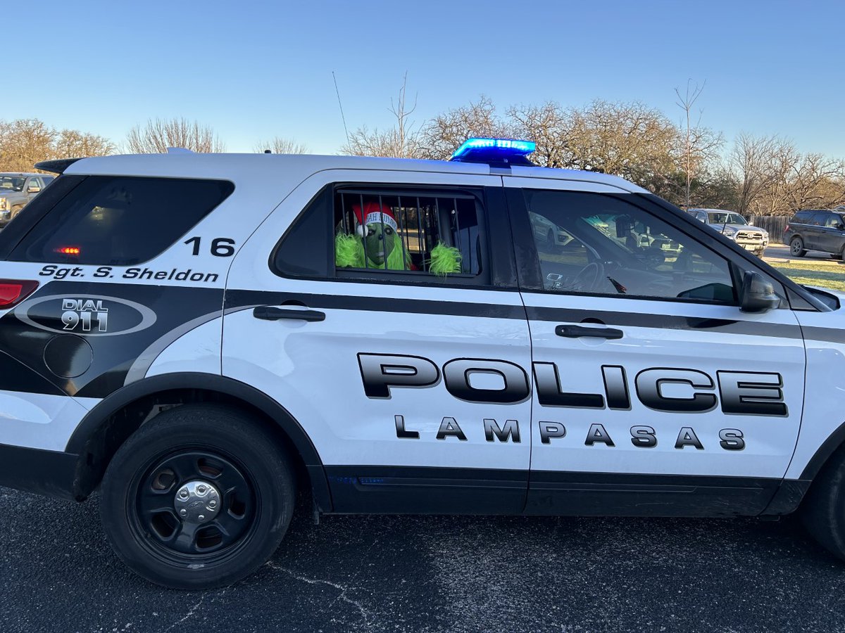 LampasasKWE's tweet photo. SRO Sheldon was not happy with the Grinch slithering and slunking around KWE at drop off this morning! 
We broke him out of jail because we LOVE our KWE GRINCH!  He makes the kids and parents laugh as he climbs in cars and tries to steal everyone's Christmas party goodies! https://t.co/sm1VMWc9zJ