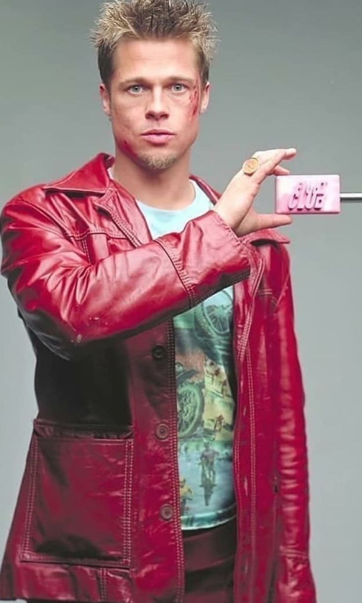 Brad Pitt as Tyler Durden holding soap with a gray background, he's looking at the camera stoically