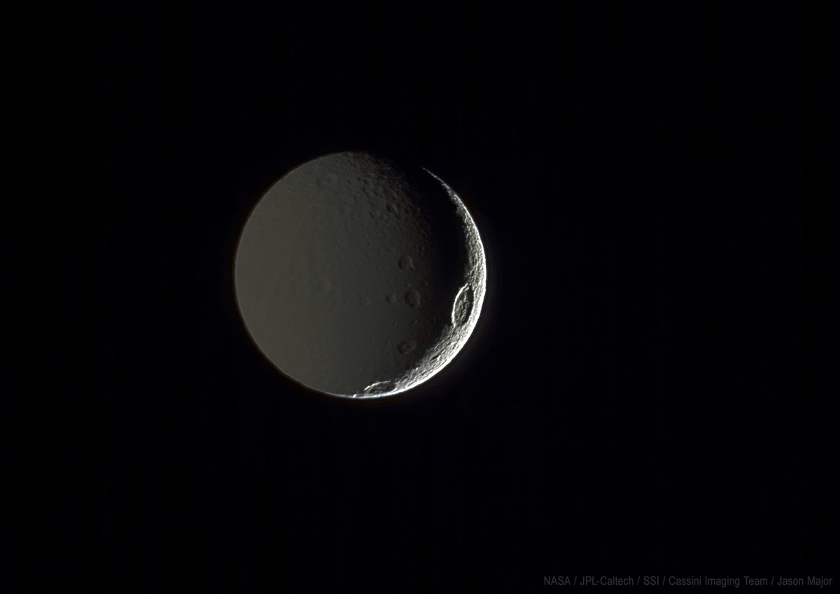 Saturn's moon Tethys (1,076 km wide) crescent-lit by sunlight on the right and reflected Saturnshine on its night side. Color composite of images captured with Cassini on August 3, 2005.
