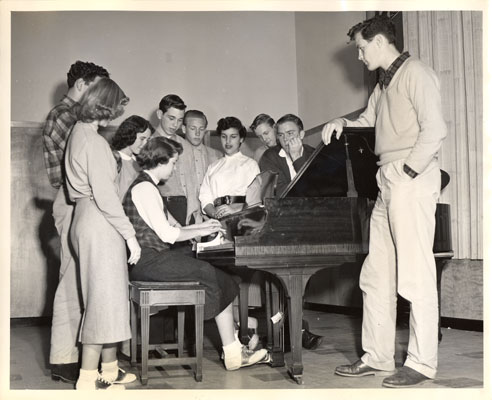 YMCA Youth in 1954 gathered by the fireplace and caroled around the piano at the YMCA Park Presidio Branch. @PresidioYMCA #flashbackfriday #YMCA #YSF #HappyHolidays Photo courtesy of @SFPublicLibrary