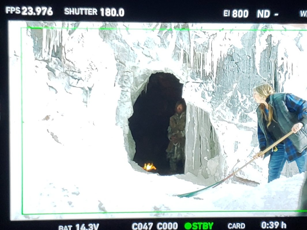 A December scene from the set of THE 100 - raking the cave door