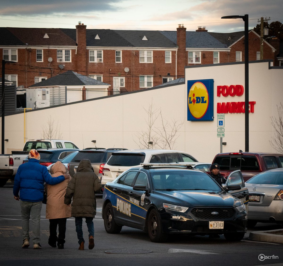 benjancewicz's tweet photo. Mourners head home, passing a Baltimore cop who does nothing.

For nearly a decade, the Northwood community in Baltimore has been calling for the @bp_plc gas station to be closed. 
Then, on Sunday, #AlStevenson was murdered at the station. 
His nephew @JamarEdwardDay protested. https://t.co/YTRwQH9nck