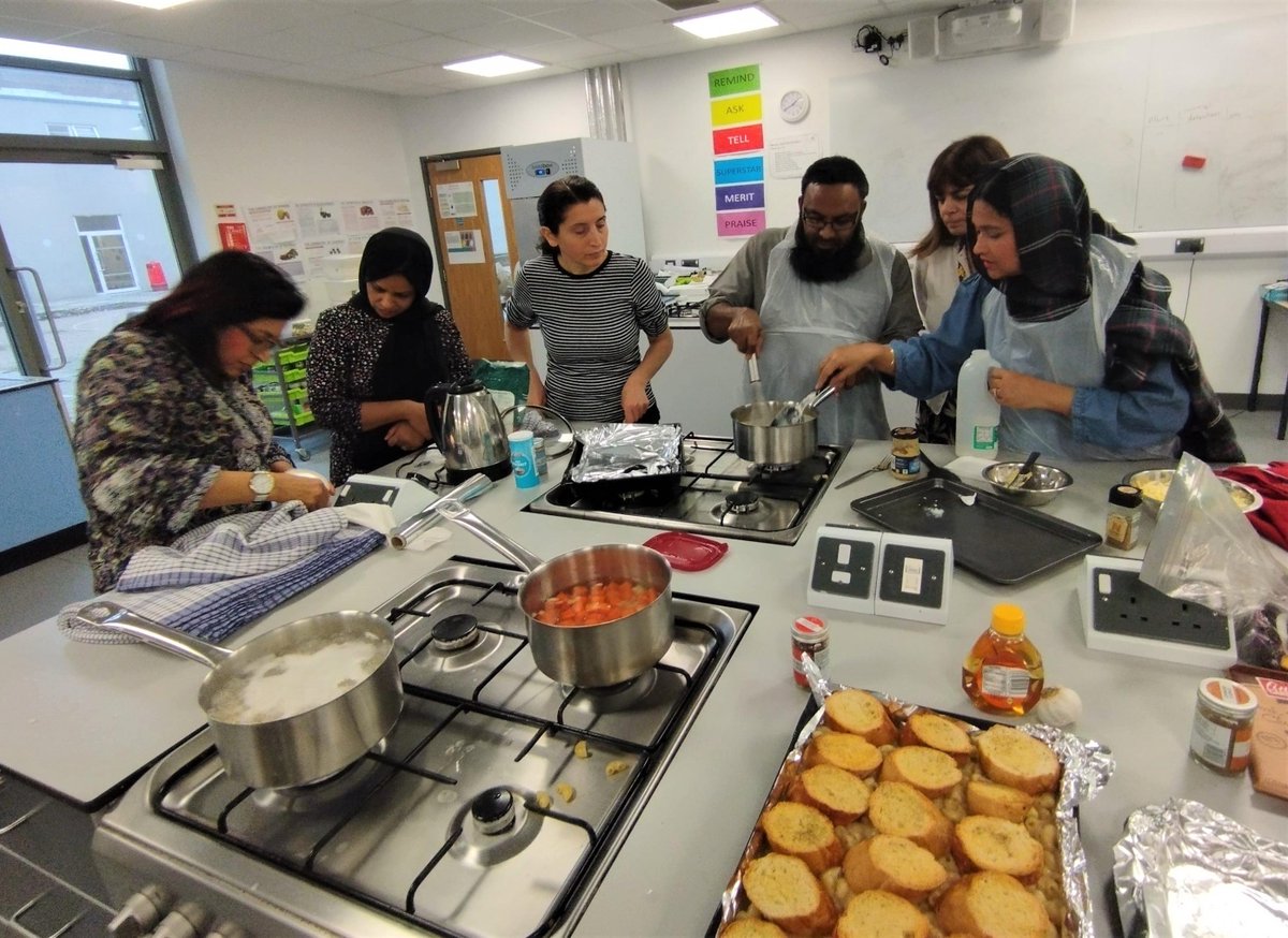 Families from across the Trust's schools enjoyed a great experience whilst participating in a series of special cooking classes with renowned television chef <a href="/TheRealManju/">Manju Malhi</a> . During the final session at Heron Hall Academy, families made Mac &amp; Cheese and a Christmas pudding trifle.