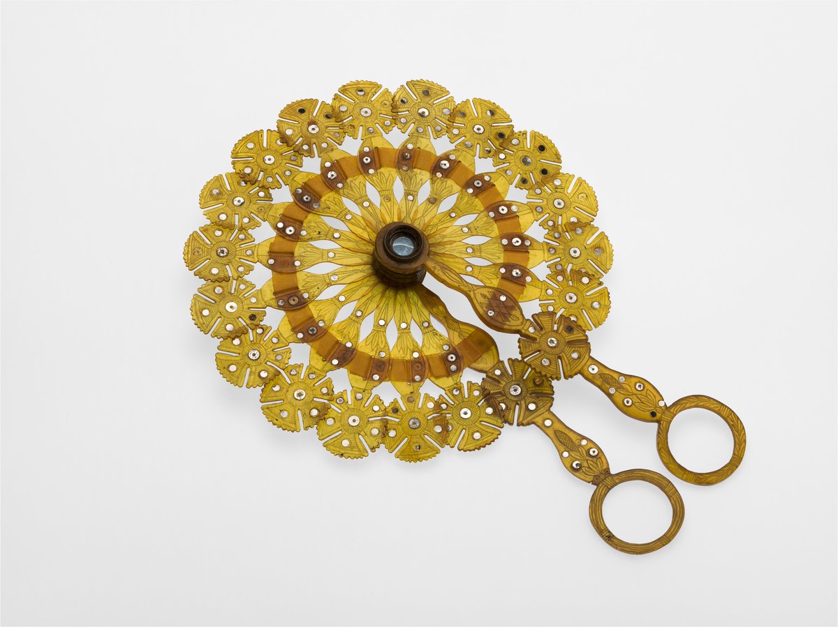 An ornate yellow fan made out of horn with a spyglass concealed in the centre. The piece is definitely more decorative than practical.
Image: Horn cockade brise fan with spyglass in central pivot. C.1810. Reproduced with permission of The College of Optometrists. Image, Wellcome Collection.