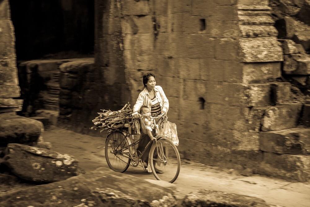 shadomoon2000's tweet photo. This is a beautiful picture of a Cambodian mother passing through the gates of the ancient temples of Angkor Wat. My friend is a noted photographer, and was randomly suspended from FB for posting this picture. #Elon, please fix FB too! #fixFB https://t.co/U3nObKZwT5