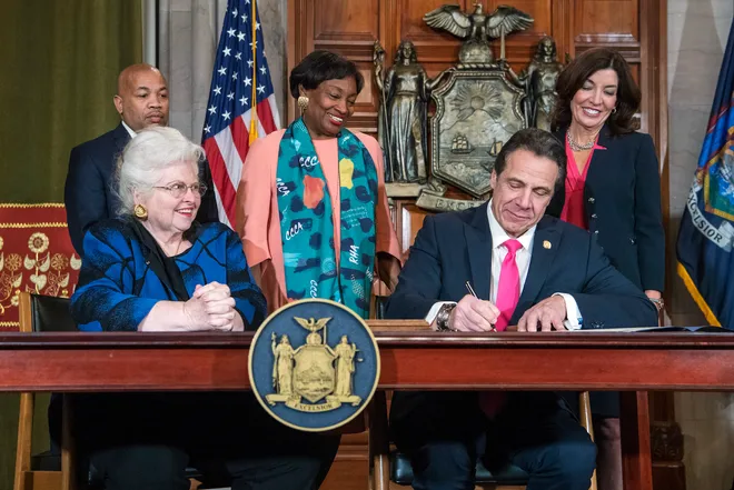 Edieisfree's tweet photo. @adalluch Here is a picture of then-governor Cuomo signing the late-term abortion bill, surrounded by smiling faces, except for the one guy in the back. I wonder what he was thinking. https://t.co/rxvpbjPsGx