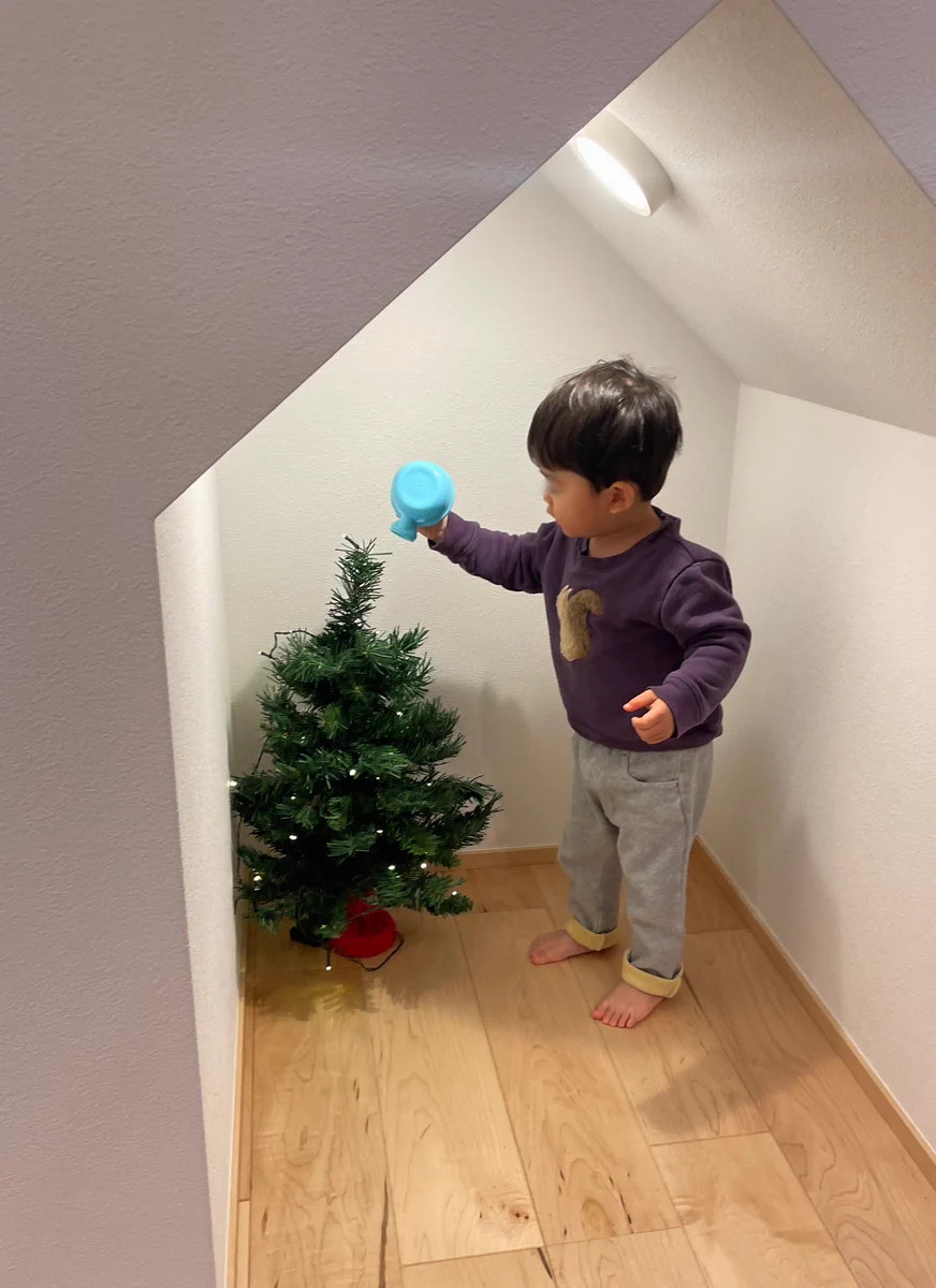 大きくなあれ♪クリスマスツリーに水をやる2歳児。