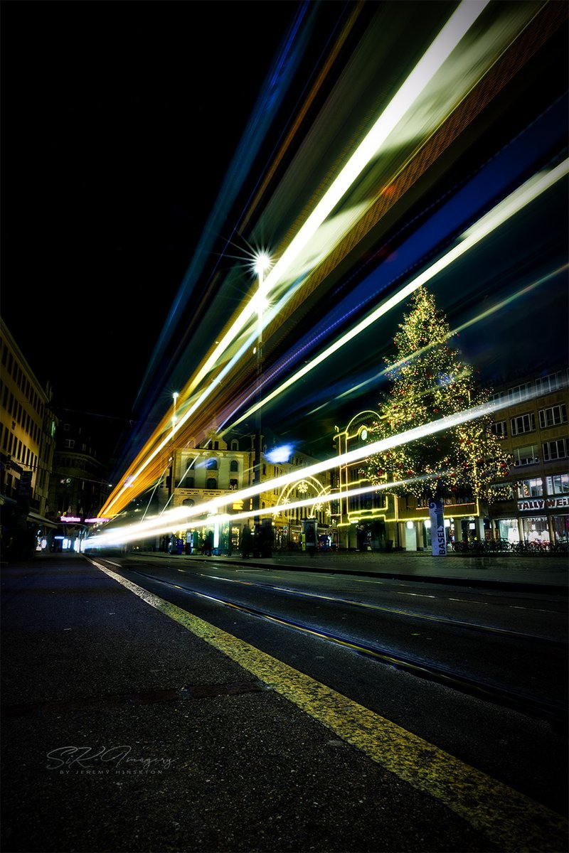 Happy #Tuesday! Today let’s see your #nightshots or #lowlight shots. ✨Bonus✨ if its #Christmas themed! 
Here’s a #longexposure of a tram in #Basel #Switzerland after enjoying the #ChristmasMarket. And a cool #ChristmasTree in the background.
Like/Comment & #retweet your favs!