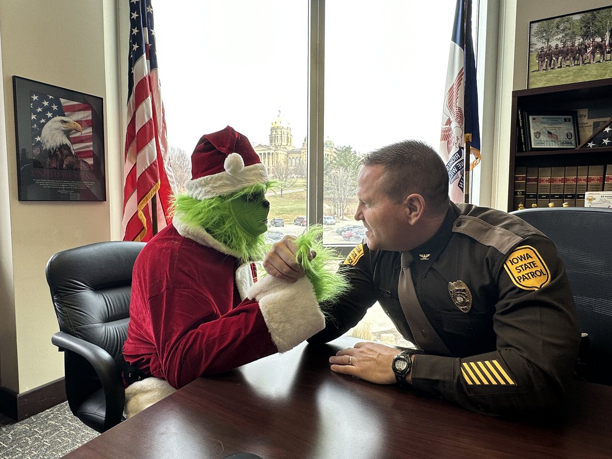 iowastatepatrol's tweet photo. Tis the season - Sergeant Dinkla spotted the Grinch not wearing his seatbelt. Off to Colonel Fulk’s office for a little talk and an arm wrestling contest! https://t.co/z8eMPhQrq1