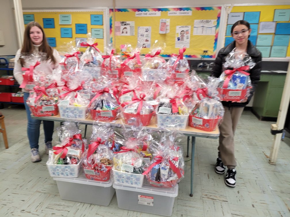 Co-presidents of the Bloomfield Middle School  National Junior Honor Society, Katelyn Estevez and Sofia Nole, displaying the Holiday Gift Baskets that the members of BMS  NJHS donated to over 30 Bloomfield seniors in need. #bmspride