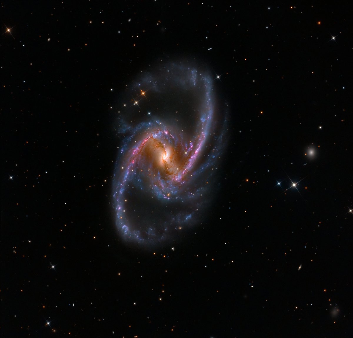 EricLagadec's tweet photo. Vous prendrez bien une petite galaxie spirale barrée pour bien commencer la journée ?
 NGC 1365 est une galaxie de l'amas de Fornax, à 60 millions d'années-lumière de nous. Au centre, un trou noir supermassif, en rose du gaz chauffé dans  des régions de formation d'étoiles. https://t.co/Itz4ePwXeb