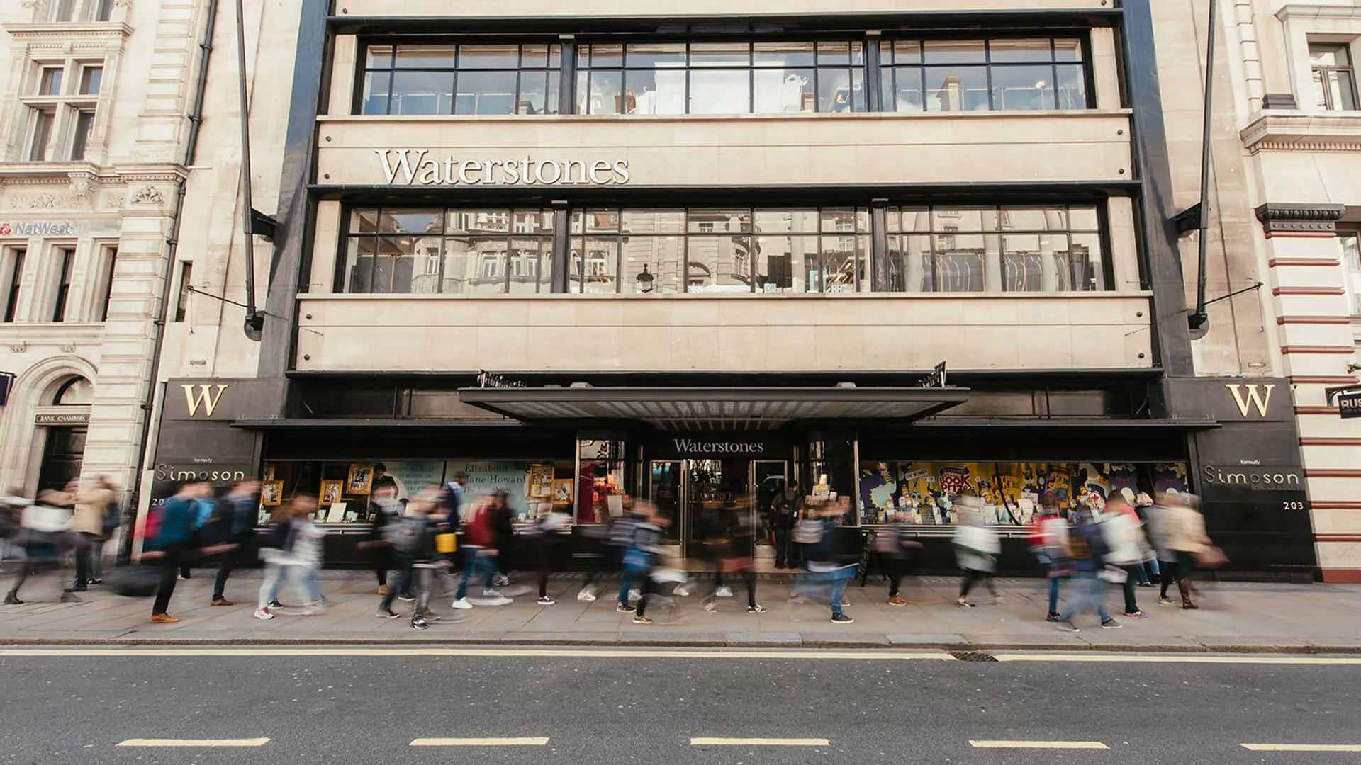 The front of Waterstones Piccadilly, with people walking past the shop in a blur. Photo credit: Mike Massaro