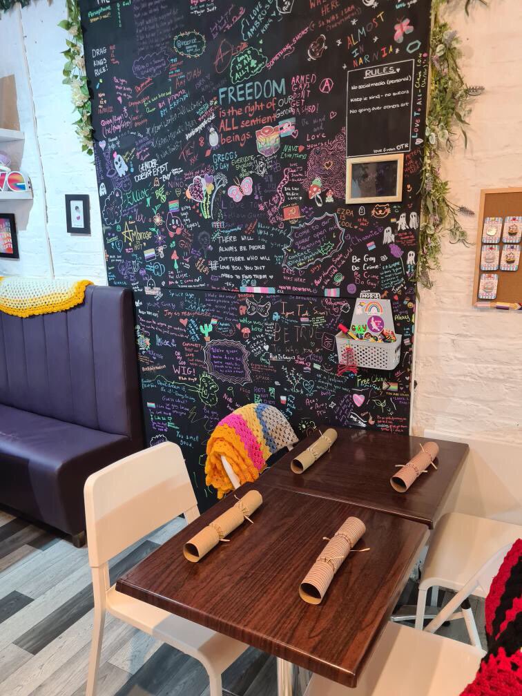 OverRainbowCafe's tweet photo. Feeling festive! Got our secular queer Christmas alternative this afternoon -  a present and a cracker for everyone, and a hearty veggie stew and lots of treats to feast on! https://t.co/43bKKOjH6k