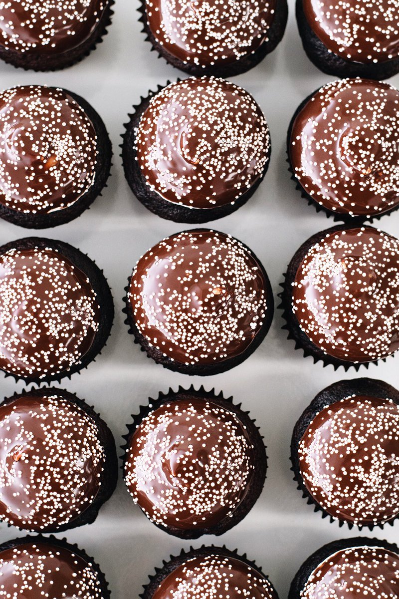 Make it a snow day with Snowcap Cupcakes 🧁 Chocolate cupcake, vanilla cream icing, chocolate ganache, and nonpareils. At both locations this month only.