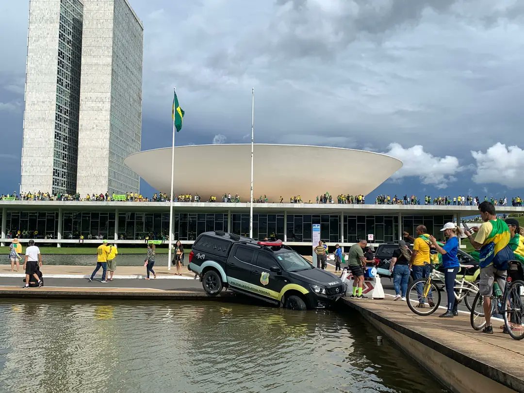 JornalOGlobo's tweet photo. Durante a invasão ao prédio do Congresso, uma viatura da Polícia Legislativa foi parar dentro do espelho d'água. Acompanhe a cobertura da invasão: https://t.co/OhjlaKmmyE https://t.co/gnFLHwFPuc