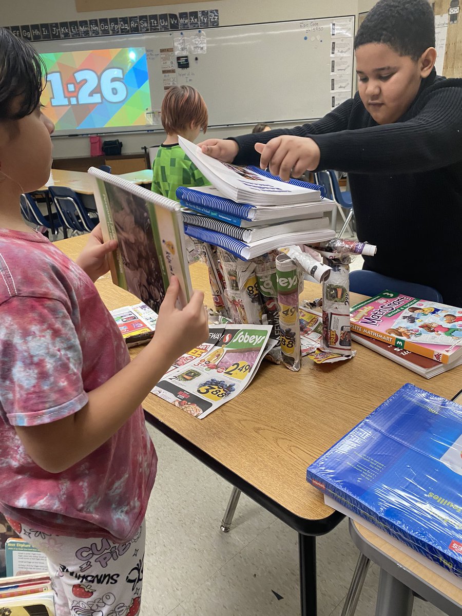 MsTiaVan's tweet photo. Room 15 is learning how to create stronger structures by adding layers &amp; folding materials. Today they were challenged to create strong structures using only grocery store flyers and tape. We tested them by seeing how many books they could hold! 📚 @lavalleeLRSD https://t.co/1DO14G7bVd
