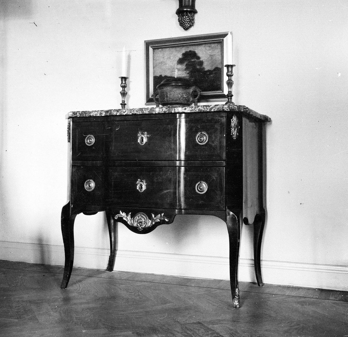 Bratténs möbler
Byrå med tavla och ljusstakar
Interiör

Svensk arkitektur: kyrkor, herrgårdar med mera fotograferade av Arkitekturminnesföreningen 1908-23.
digitaltmuseum.se/011015012701