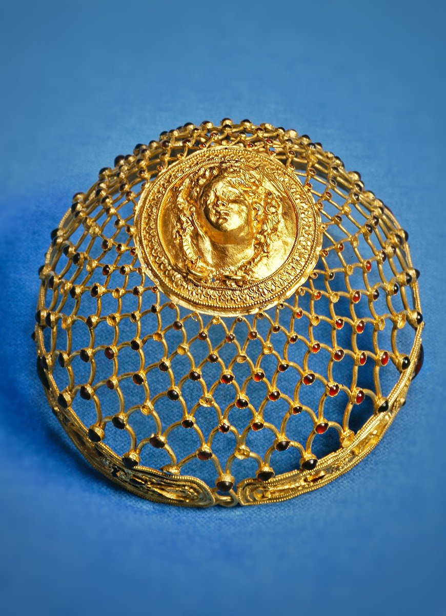 Gold hairnet with a central medallion (head of a young Medusa) and a ribbon-like base studded with garnets. 3rd c. BCE

Found in a grave in the Greek colony of Taras in South Italy (modern Taranto). 
#Archaeology
