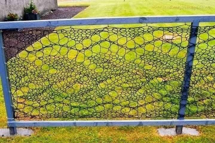 BudgetDude's tweet photo. Anne Eunson from Hamnavoe Scotland knitted a fence using black twine that’s used for making fishing nets. It took about 3 weeks on specially adapted curtain rods to knit enough lace to surround her front garden, using a 23 stitch repeat of a familiar Shetland lace pattern. https://t.co/GXRJjldRkD