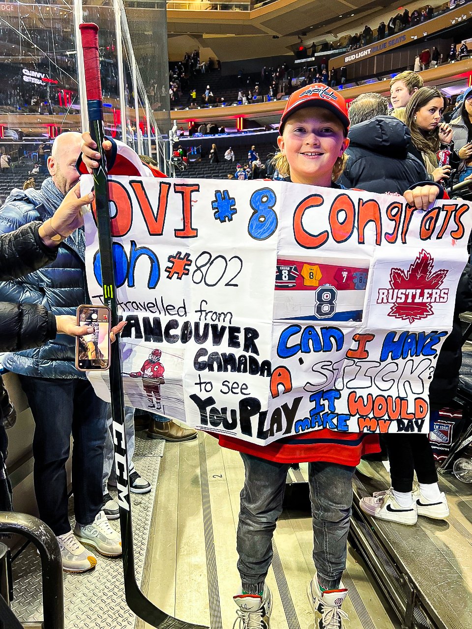 A young Caps fan poses with Alex Ovechkins hockey stick after traveling all the way from Vancouver with a sign asking for Ovis hockey stick 