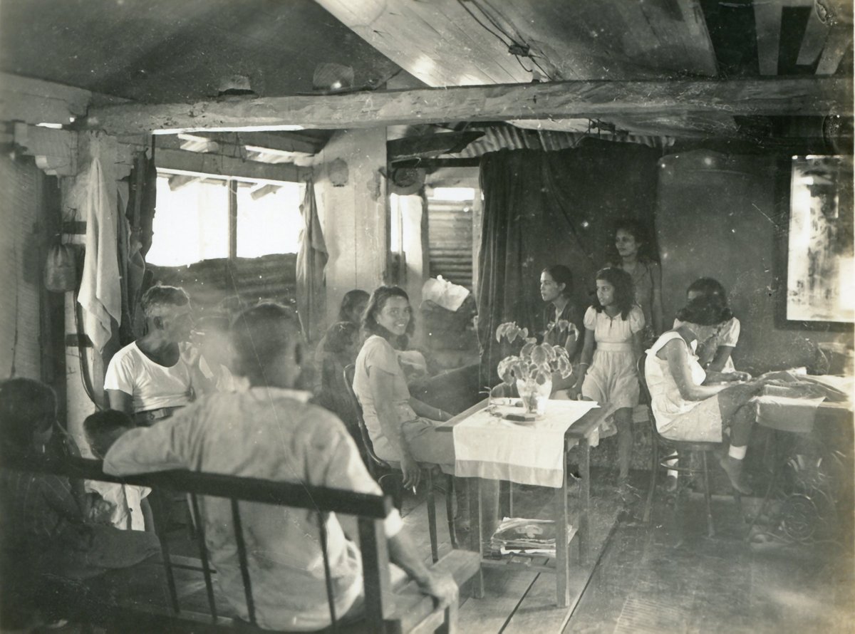 guammuseum's tweet photo. An image of a CHamoru family in their home, in the immediate post-World War II years on Guam. The photo has no information indicating the family, village or exact year. If you can help with identification in any way, please reach out to the Guam Museum on social media. https://t.co/pYBMtQaSgs