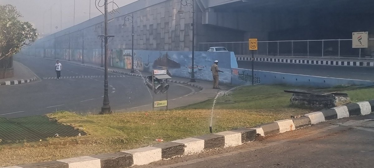 rishisingla's tweet photo. What a sight... A person watering with hose while the sprinklers are on. Great work outside Navi Mumbai Mahanagar Palika Headquarters. #toi #nmmp #indiatv https://t.co/XtJ8AMHNOB