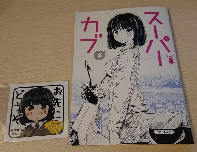 SIN()さんのスーパーカブ新刊とステッカーです。ぽつぽつ入る昔のアニメネタが笑えました。あと「好き」の熱量が凄い。「椎がいちばんイカれてる」ってのは心から同意しますwステッカー、小熊さん可愛く描いてるのに「原付煽って楽しい?」と煽り返してるのがイイ!w 