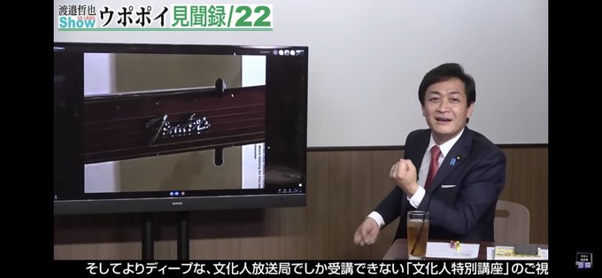 玉木が、OKIのトンコリに貼られたフェンダーのエンブレムの写真をみて、ギターをひくマネをして笑っている