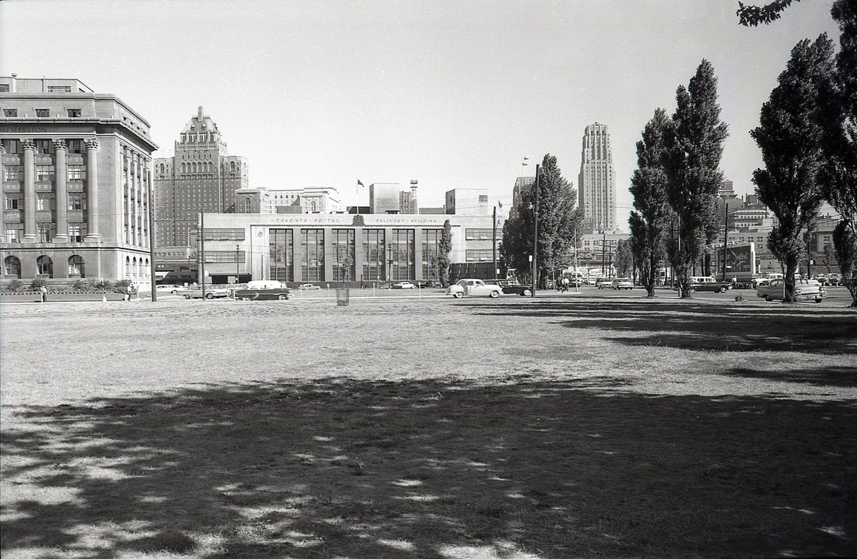 g_meslin's tweet photo. TPB scan #167
A good one to start 2023.
Looking north from Queens Quay West, just west of Bay, an unobstructed (pre-Gardiner) view of the Toronto Postal Delivery Building (now Scotiabank Arena). Harbour Commission Bldg to the left. Field in the foreground is now Waterpark Place. https://t.co/ps86VphEST