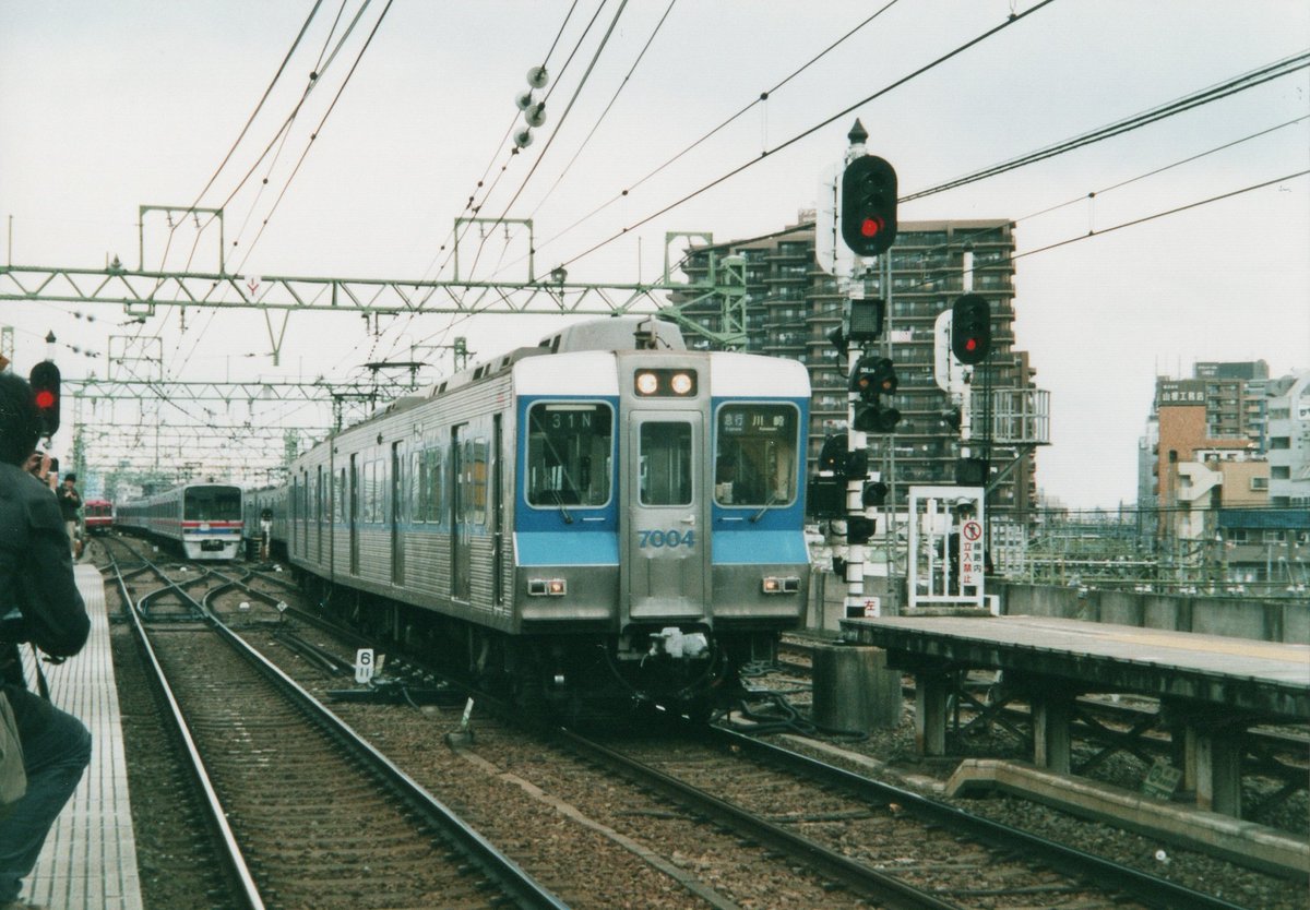 bbb1017817's tweet photo. 「箱根駅伝と京急」と言えば第一京浜と交差する空港線の踏切です。
選手が通過する時間帯の羽田空港ゆきは京急川崎ゆきに変更して、折返し上り列車は京急蒲田まで回送して運転されていました。
この光景は高架化が完了した2012年をもって見納めになりました。
こちらは2006年当時の様子です。 https://t.co/BVM1F2Cgbf