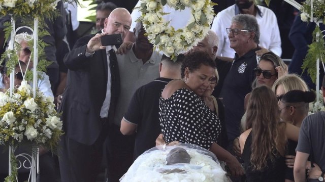 TrollFootball's tweet photo. FIFA president taking a selfie right next to Pelé's open coffin https://t.co/h7fqt3QHPo
