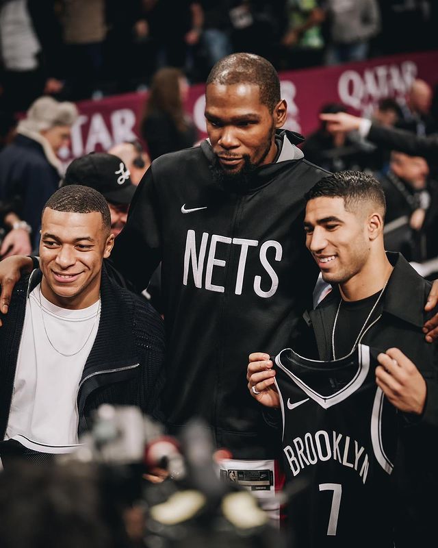 PortalMbappe's tweet photo. 📸| ELE É BAIXINHO 🤣!
Kylian esteve com seu amigo Hakimi em um jogo da NBA ontem, os jogadores recebem uma jersey diretamente das mãos de Durant.
Fotos do Instagram. https://t.co/WG0dRhG6SW