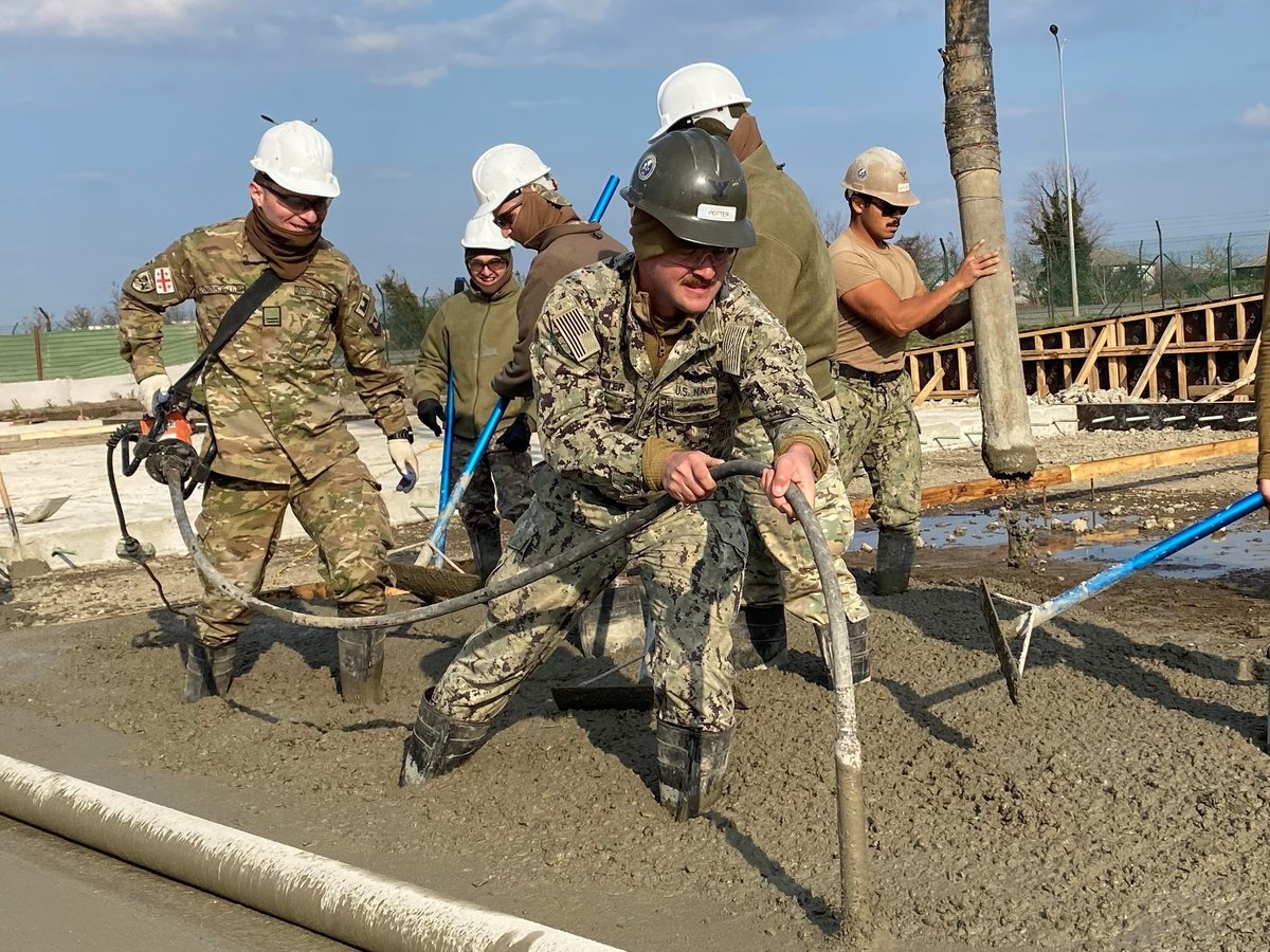 USNavy's tweet image. Helping cement our partnership! 
🇺🇸 🤝 🇬🇪 
#NavyPartnerships 

#USNavy #Seabees assigned to #NMCB11 work with soldiers assigned to the Georgian Land Force’s 2nd Brigade Engineering Company to vibrate and strengthen a concrete pad for the Railhead Project in Poti, Georgia.