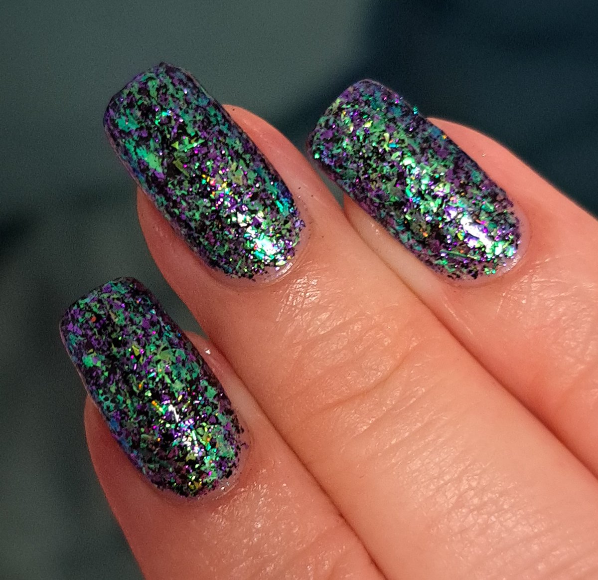 This week's polish: Witching Hour from #RogueLacquer is a green to blue glass fleck flake polish, with purple and black metallic flakes in a clear base. 💅💚💙💜🖤✨️ #nailpolishaddict #givemesparkles