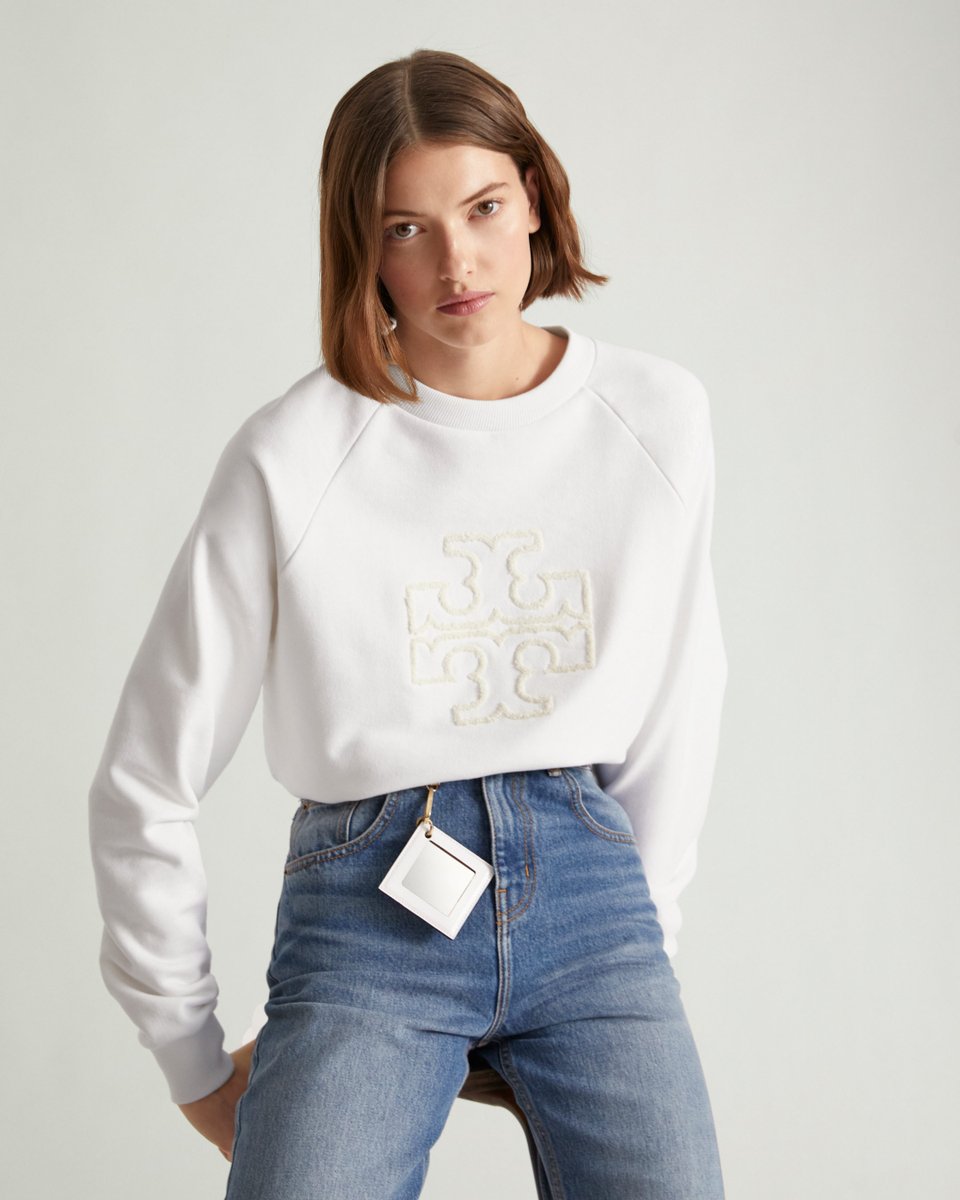 Just in: a raglan-sleeve crewneck appliquéd with a chenille Double T, crafted in warm merino French terry. Shop new arrivals that keep you cozy on the go. #TorySport