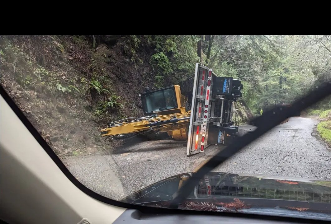 Thepitbulllady's tweet image. Large truck with flatbed trailer carrying a backhoe flipped into it's side on Lompico road, expect closures and delays for getting out of the canyon for at least a few hours. #lompico #zayante #felton #santacruzmountains